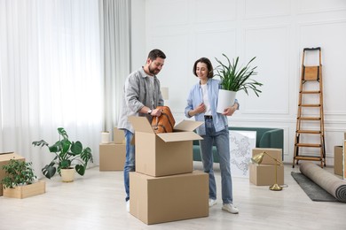 Photo of Moving day. Happy couple unpacking their belongings in new home