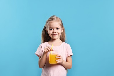 Photo of Girl with glass of orange juice on light blue background. Refreshing drink