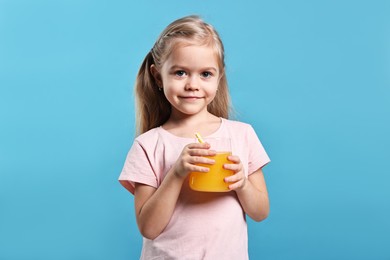 Photo of Girl with glass of orange juice on light blue background. Refreshing drink