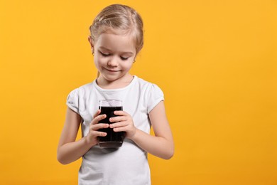 Photo of Girl with glass of refreshing soda drink on orange background