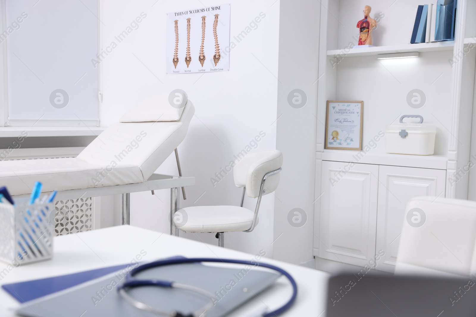 Photo of Stethoscope and folders on desk in medical office, closeup