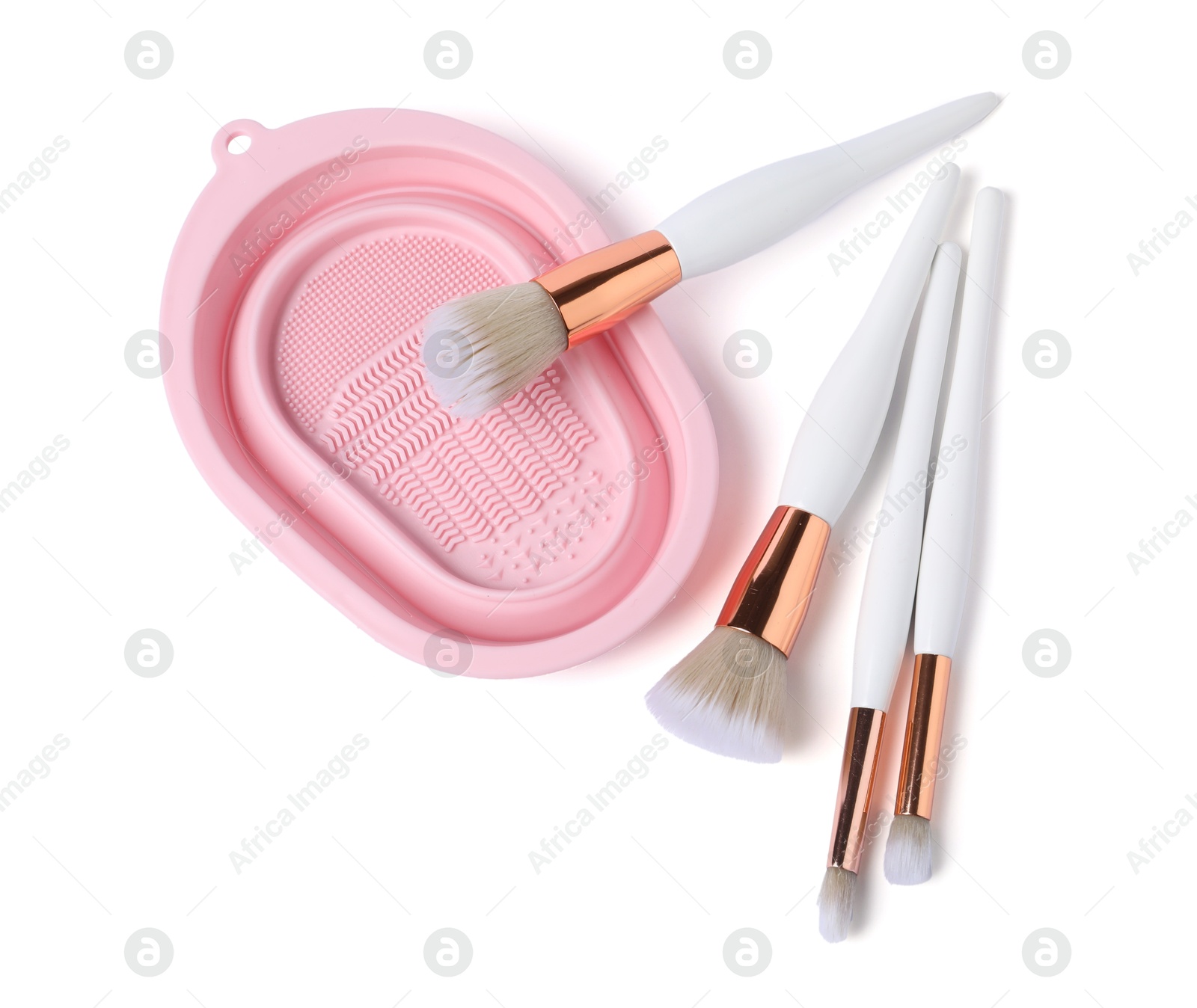 Photo of Makeup brushes and cleansing pad isolated on white, top view