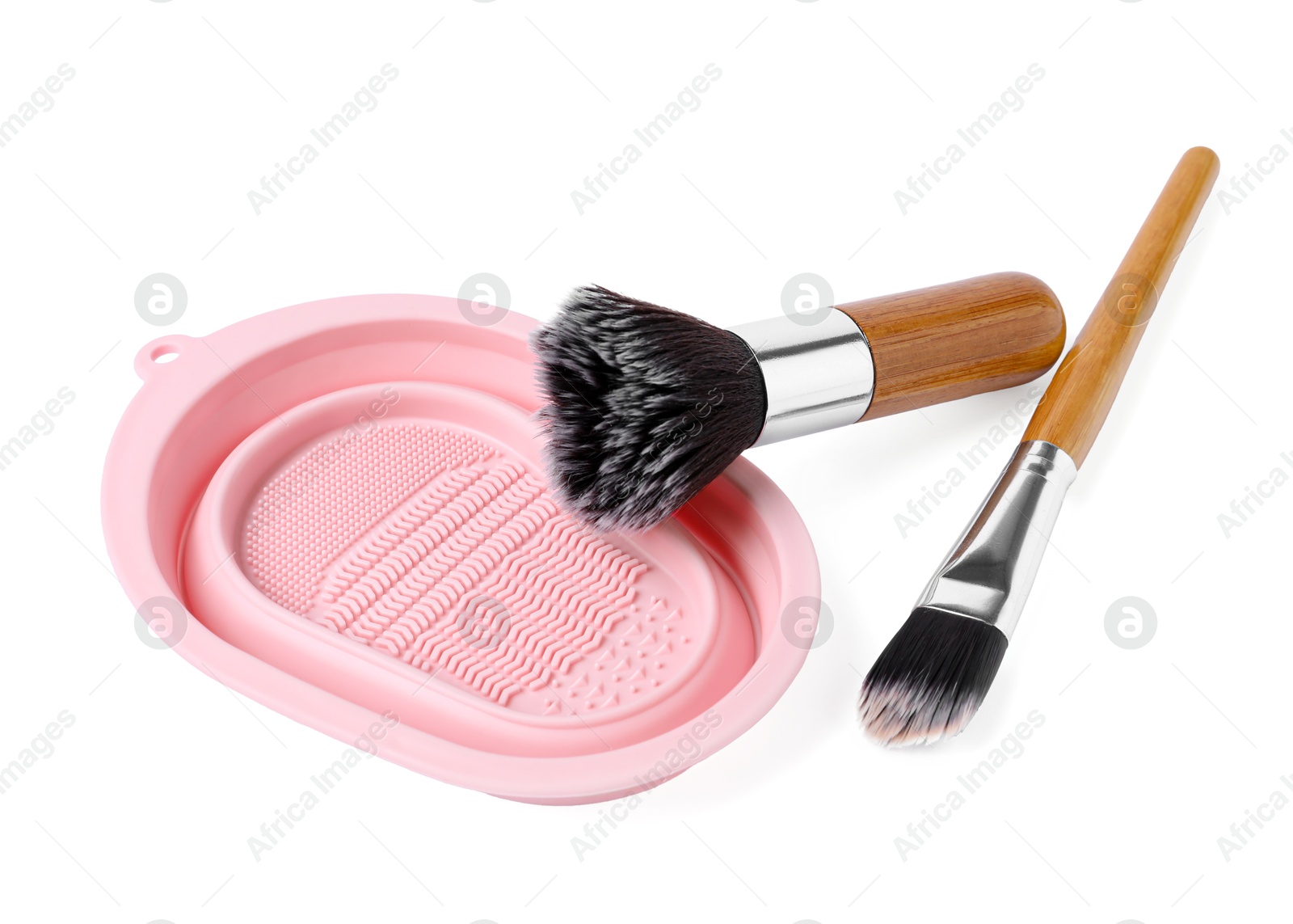 Photo of Makeup brushes and cleansing pad isolated on white