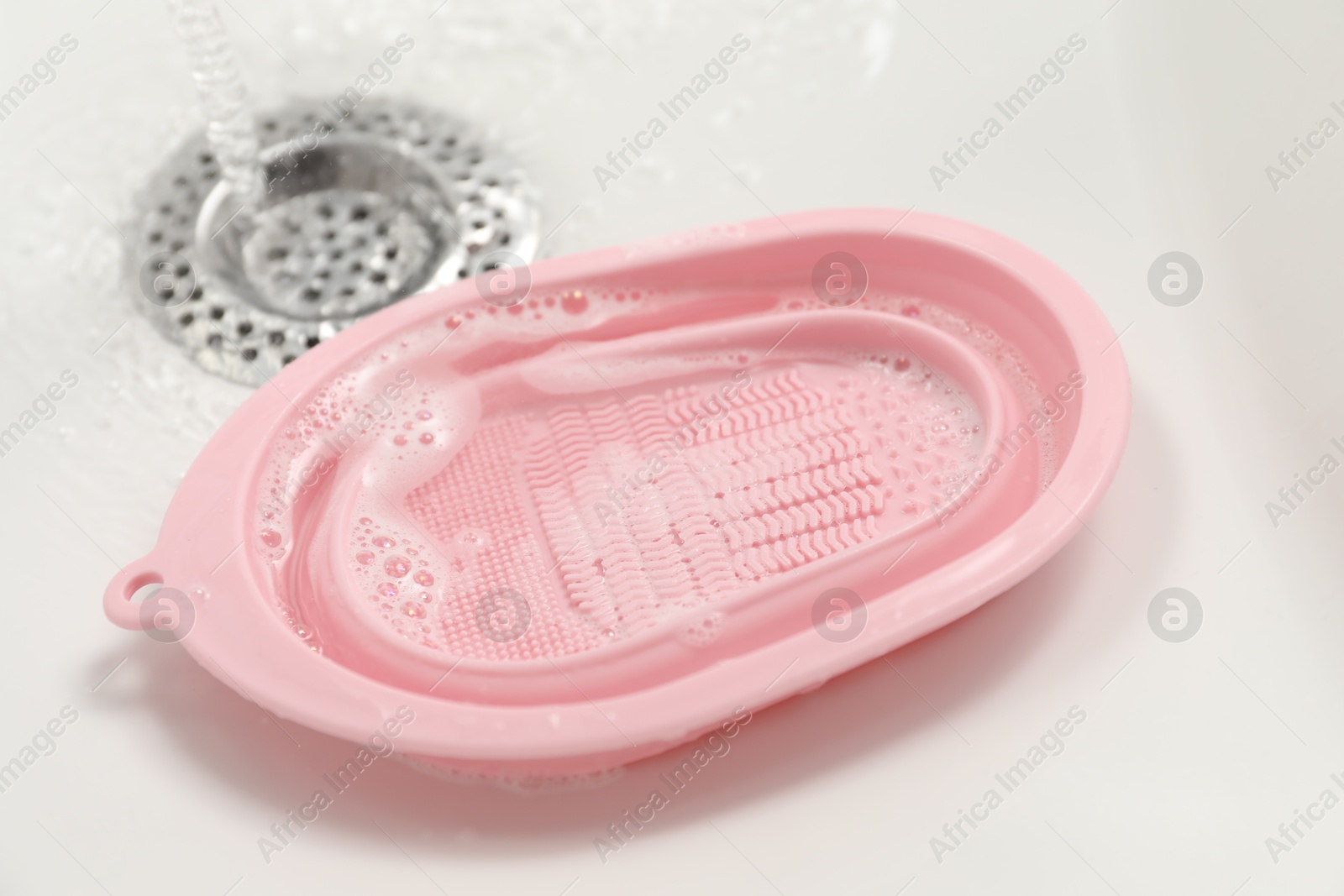 Photo of Silicone pad for cleaning makeup brushes in sink, closeup