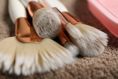 Photo of Clean makeup brushes on brown towel, closeup