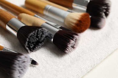 Photo of Clean makeup brushes on white table, closeup