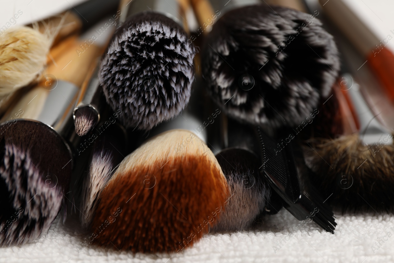 Photo of Clean makeup brushes on towel, closeup view