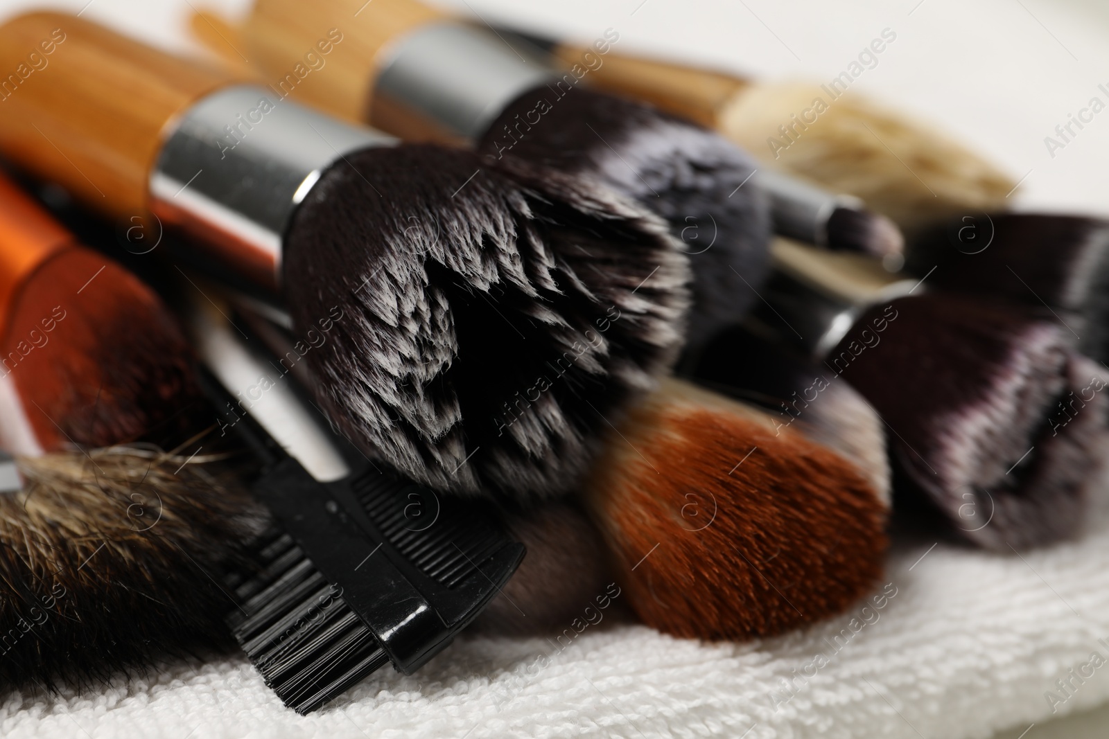 Photo of Clean makeup brushes on towel, closeup view