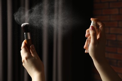 Photo of Woman cleaning makeup brush with spray indoors, closeup