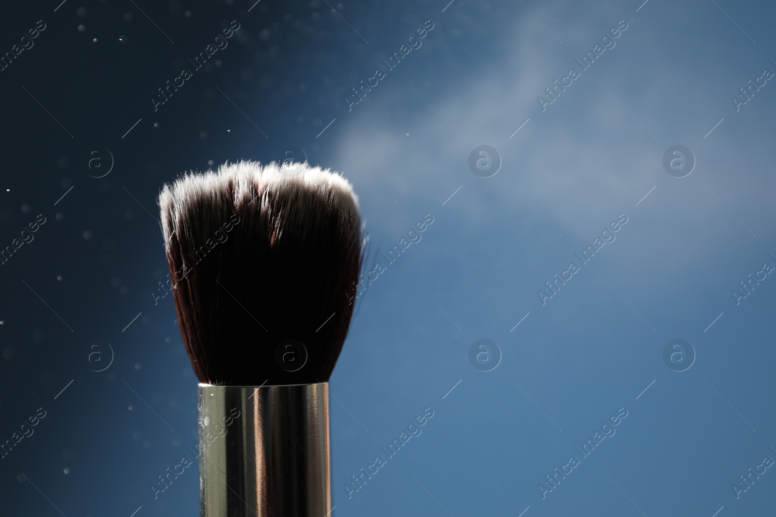 Photo of One clean makeup brush on blue background, closeup. Space for text