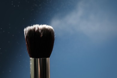 Photo of One clean makeup brush on blue background, closeup. Space for text