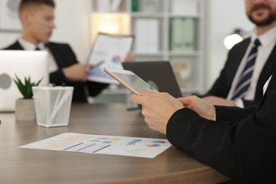 Photo of Coworkers working together at wooden table in office, selective focus