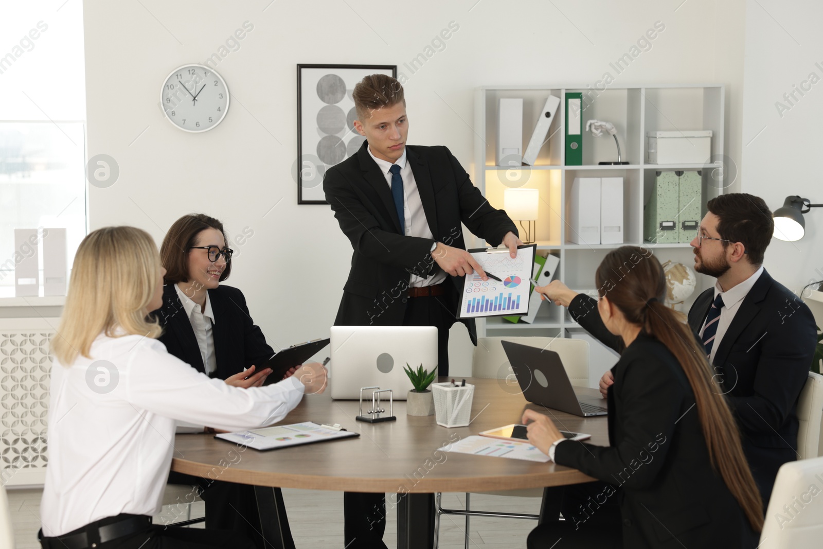 Photo of Group of coworkers having meeting in office