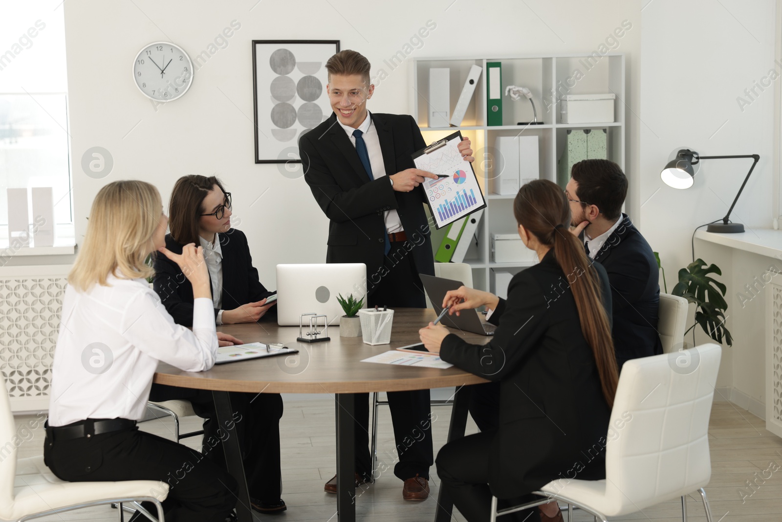 Photo of Group of coworkers having meeting in office