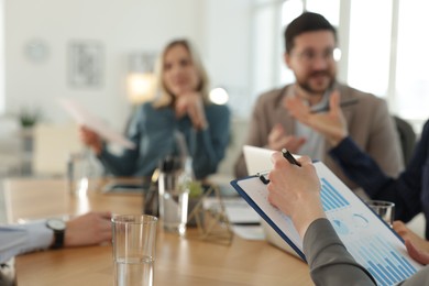 Photo of Coworkers working together at table in office, selective focus