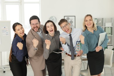 Photo of Portrait of happy coworkers in formal clothes indoors