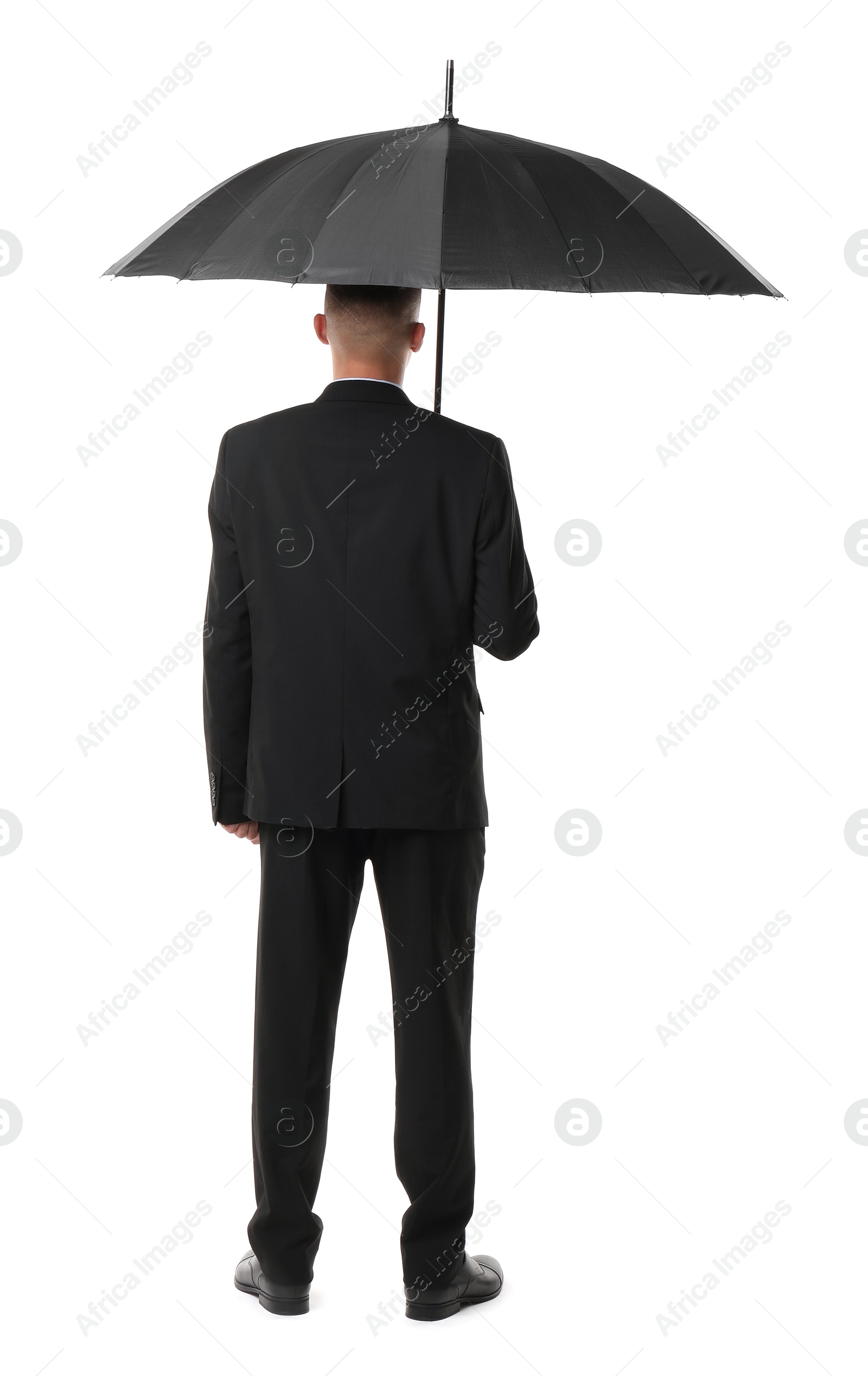 Photo of Man in suit with black umbrella on white background, back view