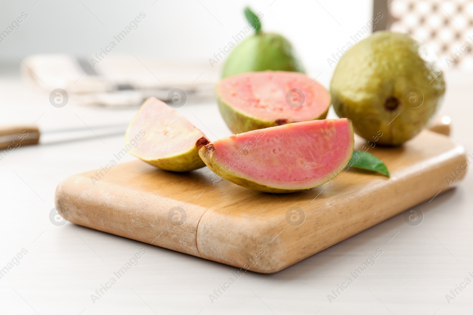 Photo of Fresh guava fruits on white wooden table, closeup