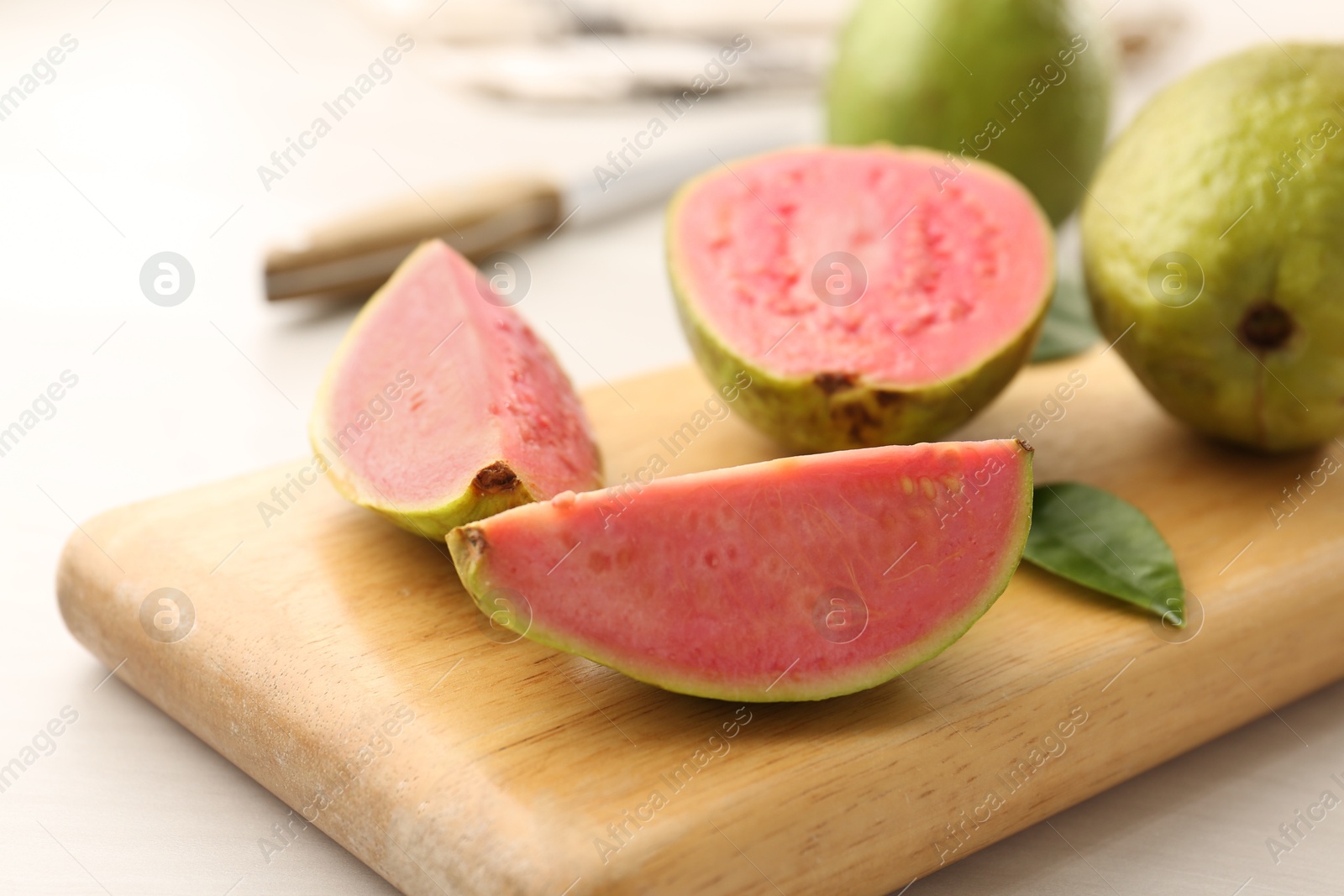 Photo of Fresh guava fruits on white wooden table, closeup