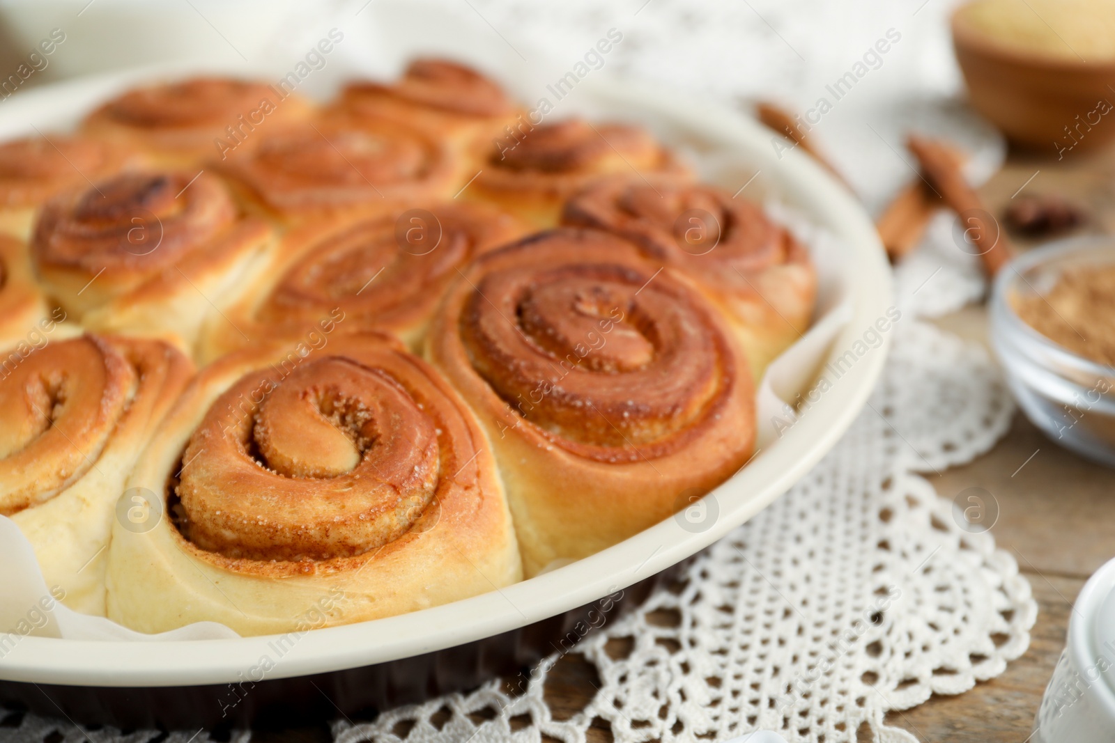 Photo of Freshly baked cinnamon rolls on wooden table, closeup