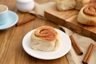 Photo of Freshly baked cinnamon roll on wooden table, closeup