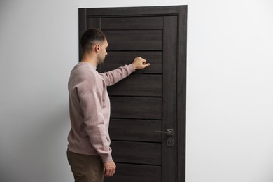 Photo of Man knocking on door to his friends apartment