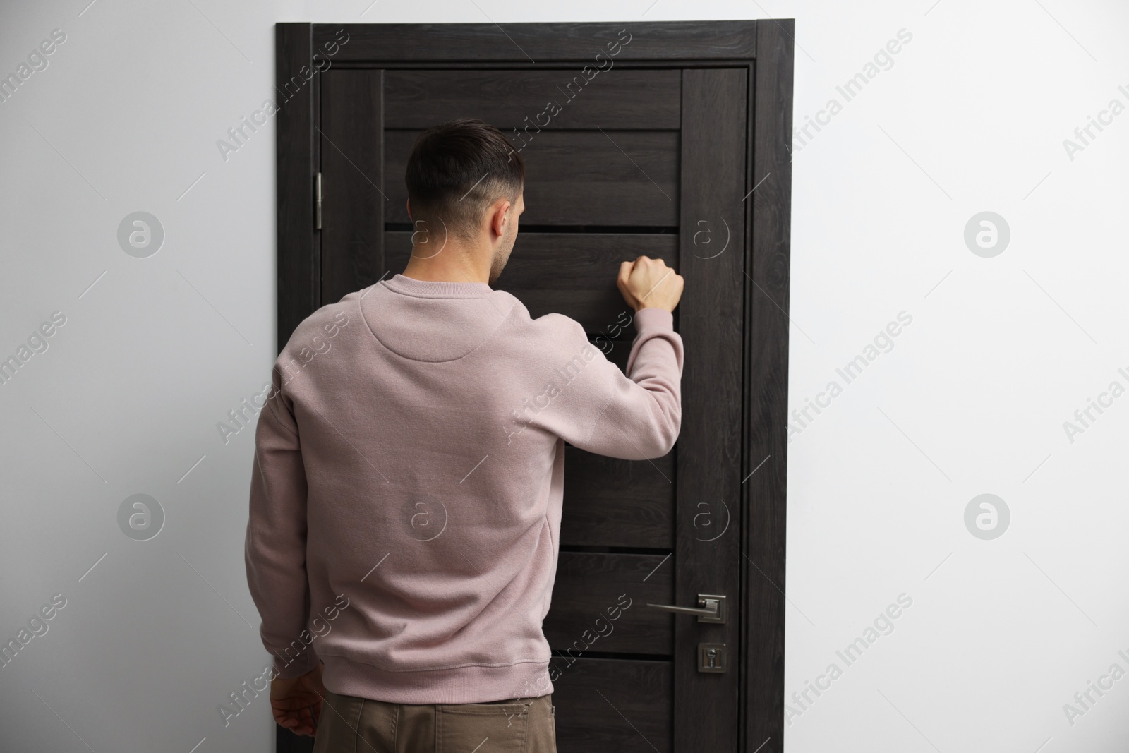 Photo of Man knocking on door to his friends apartment