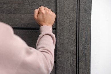 Photo of Man knocking on door to his friends apartment, closeup