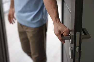 Photo of Cheerful man meeting guests in doorway of his apartment, closeup