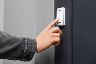 Photo of Man ringing doorbell of his friends apartment, closeup