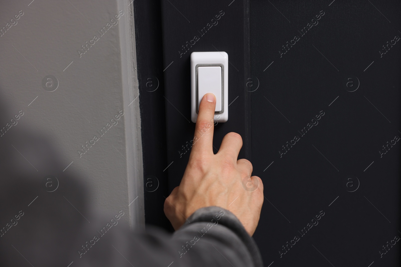 Photo of Man ringing doorbell of his friends apartment, closeup