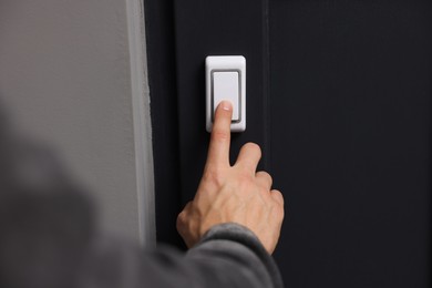 Photo of Man ringing doorbell of his friends apartment, closeup