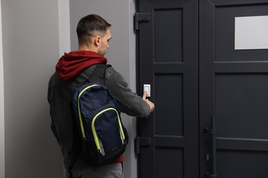 Photo of Man ringing doorbell of his friends apartment