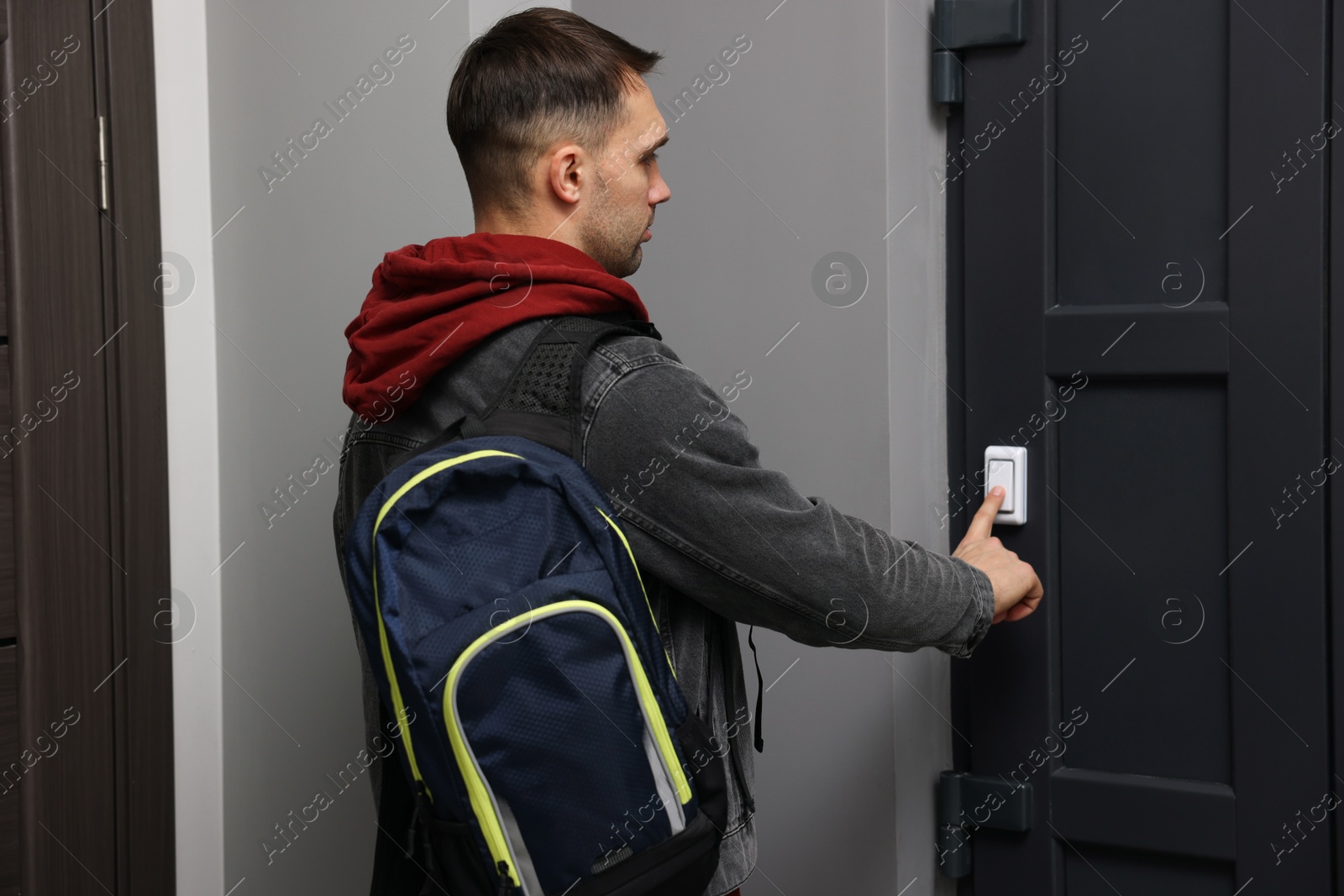 Photo of Man ringing doorbell of his friends apartment