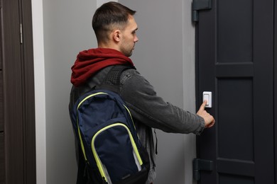 Photo of Man ringing doorbell of his friends apartment