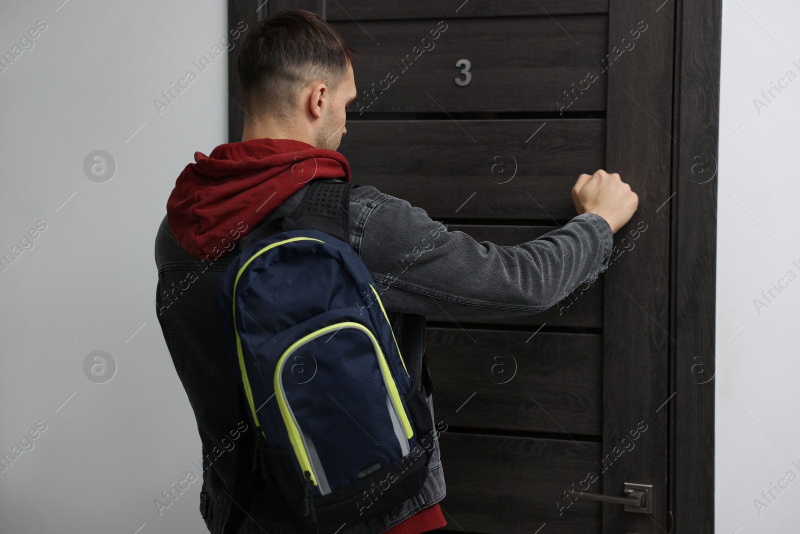 Photo of Man knocking on door of his friends apartment