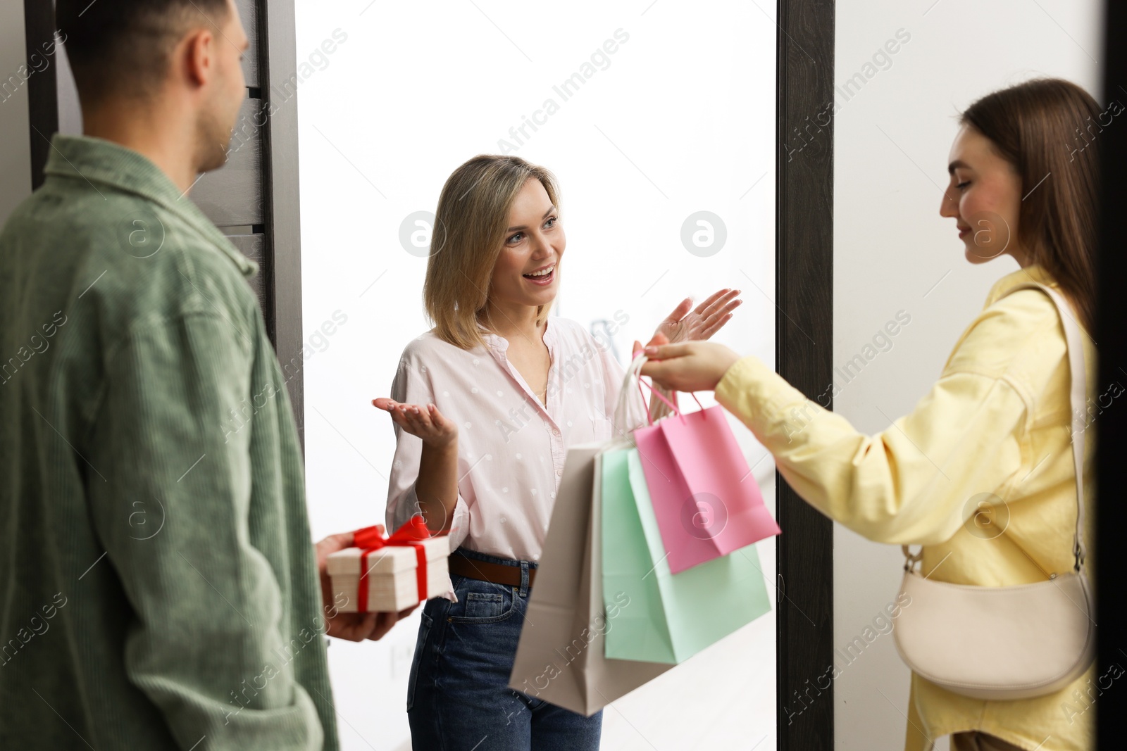 Photo of Cheerful woman welcoming guests to her housewarming party