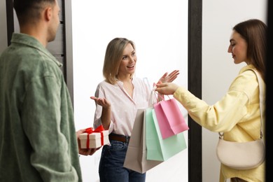 Photo of Cheerful woman welcoming guests to her housewarming party