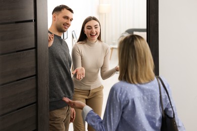 Photo of Lovely couple welcoming friend to their apartment