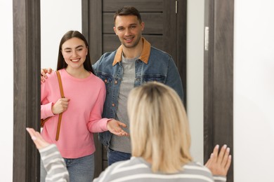 Photo of Woman welcoming new neighbors to her apartment