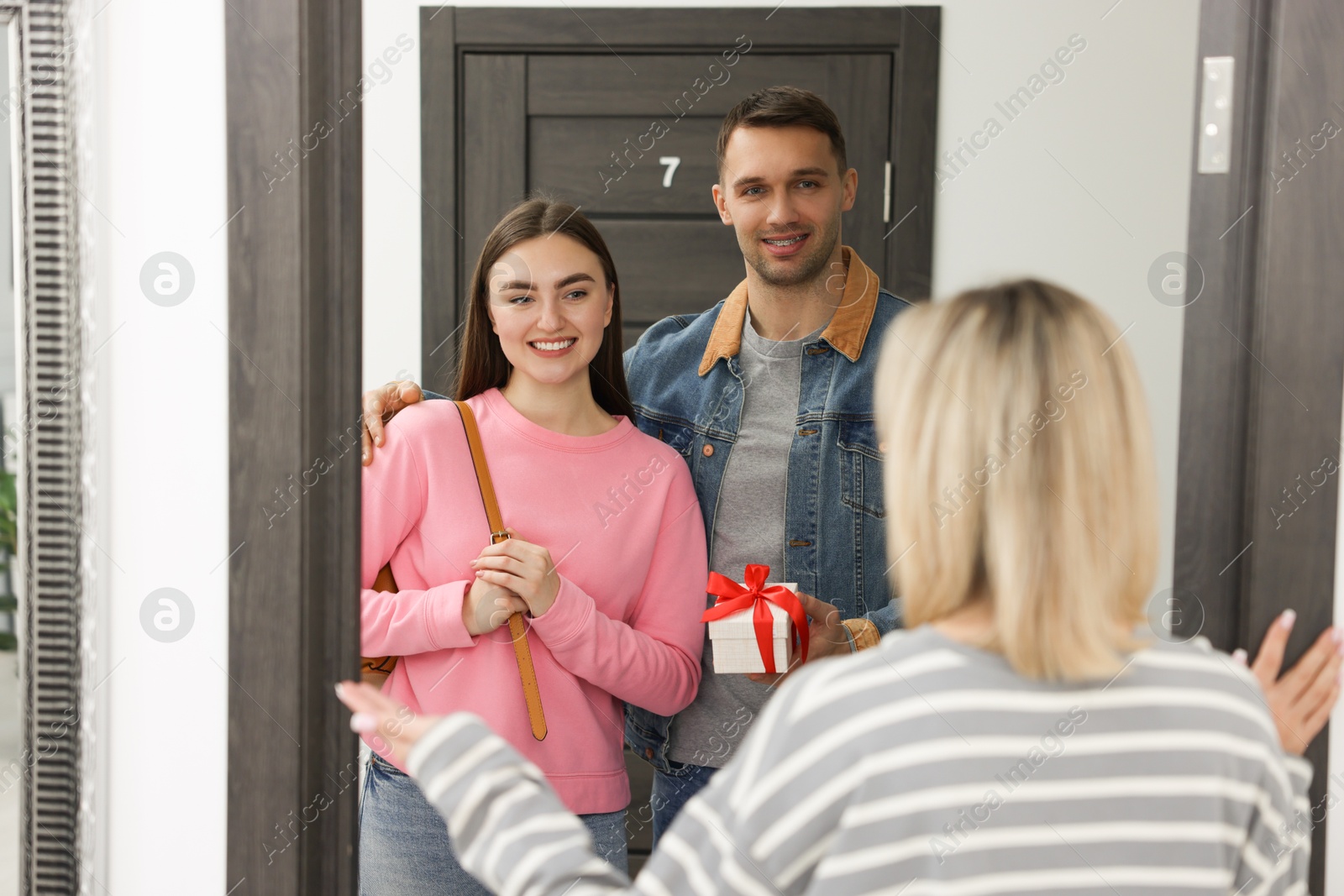 Photo of Lovely couple giving housewarming gift to their new neighbor