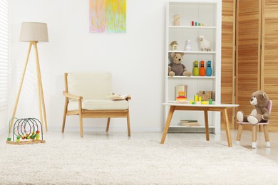 Photo of Different toys and stylish furniture in child's room