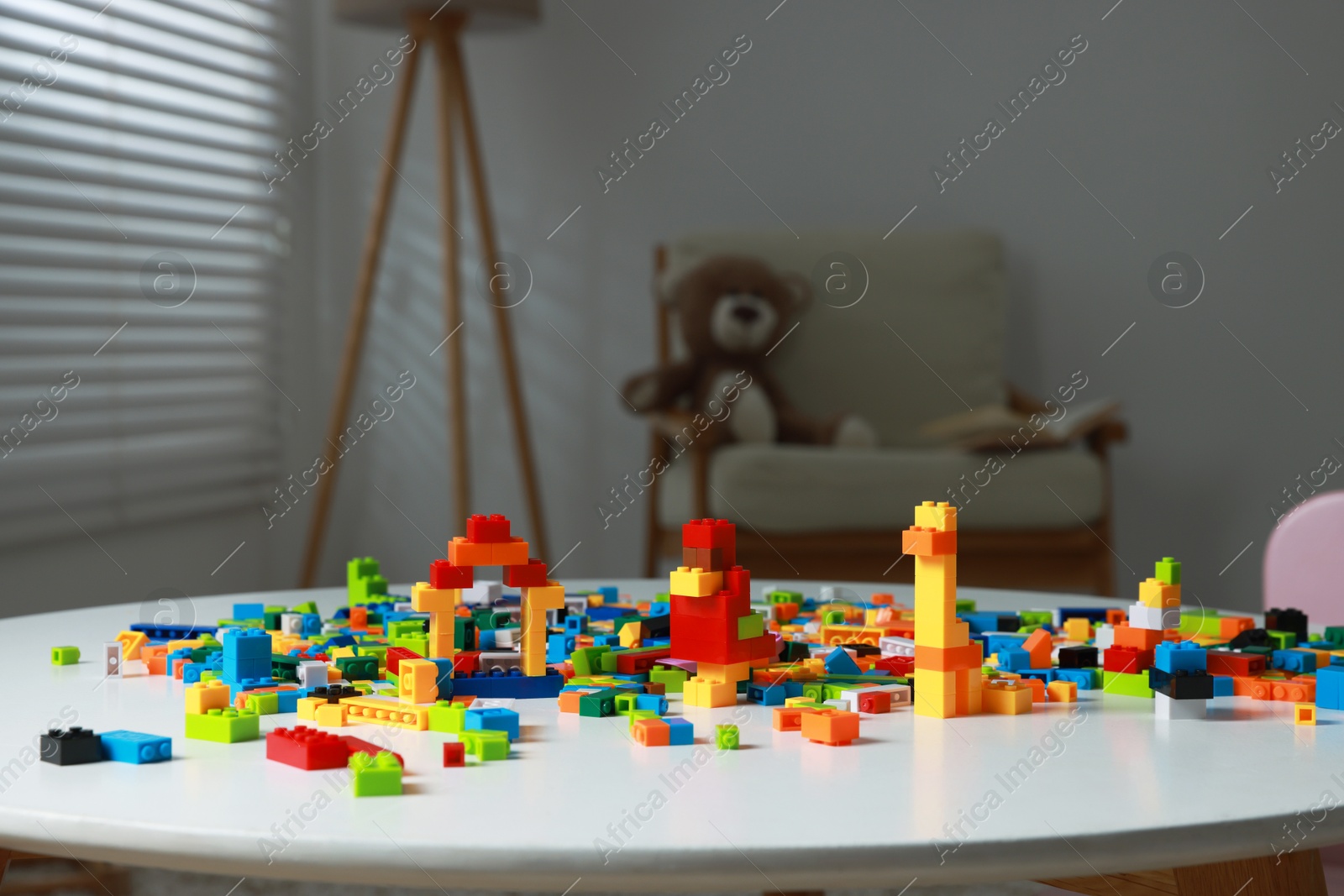 Photo of Construction toy. Colorful building blocks white table indoors