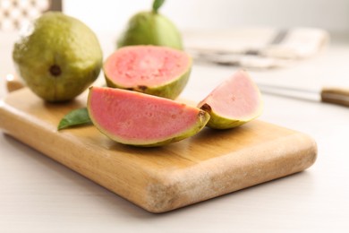 Photo of Fresh guava fruits on white wooden table, closeup