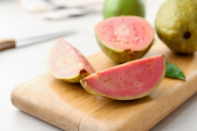 Photo of Fresh guava fruits on white wooden table, closeup