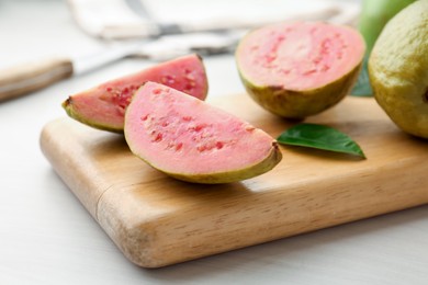 Photo of Fresh guava fruits on white wooden table, closeup