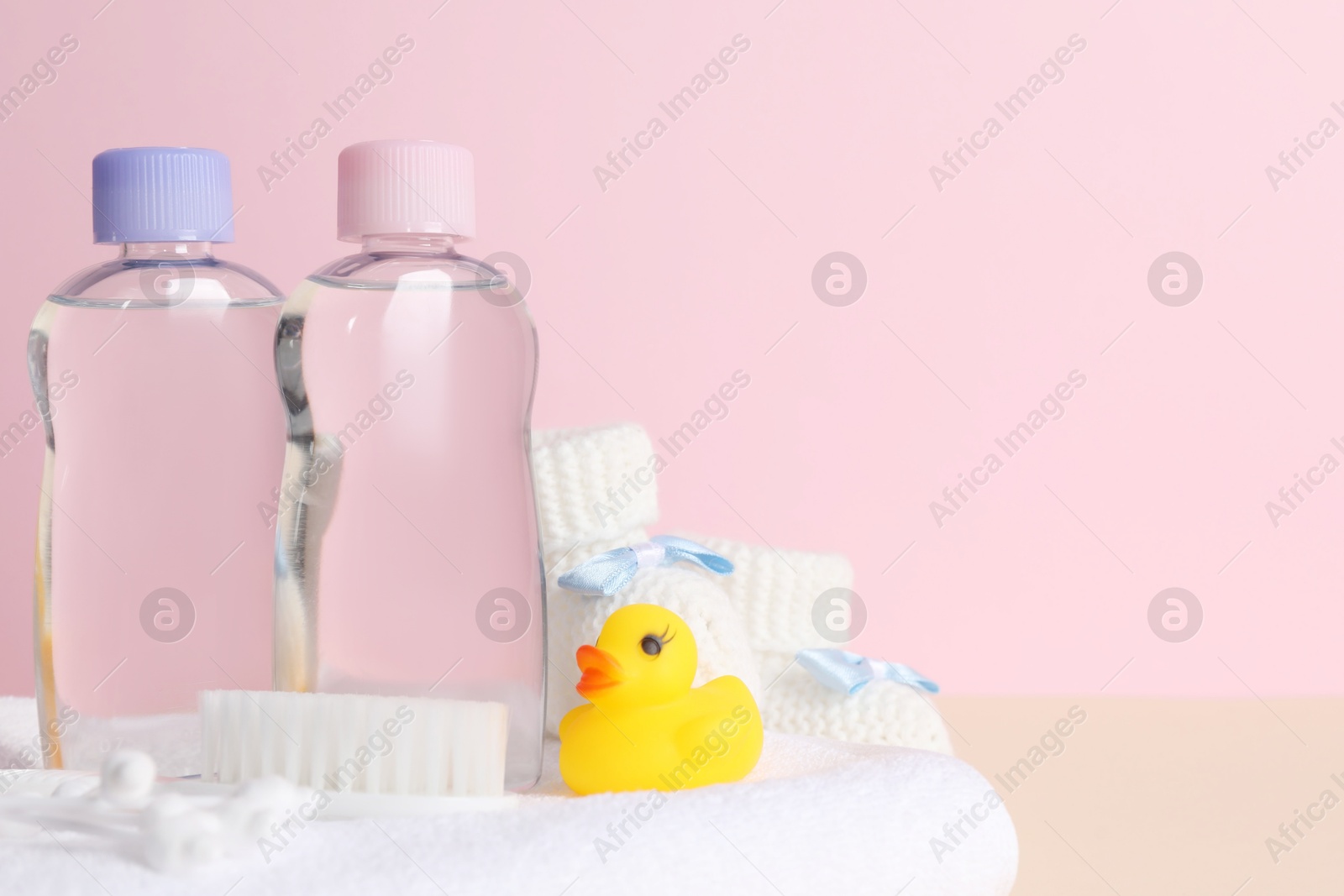 Photo of Baby oil and bath accessories on color background, closeup. Space for text