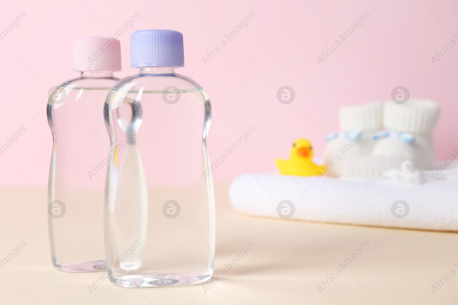 Photo of Baby oil and bath accessories on color background, selective focus