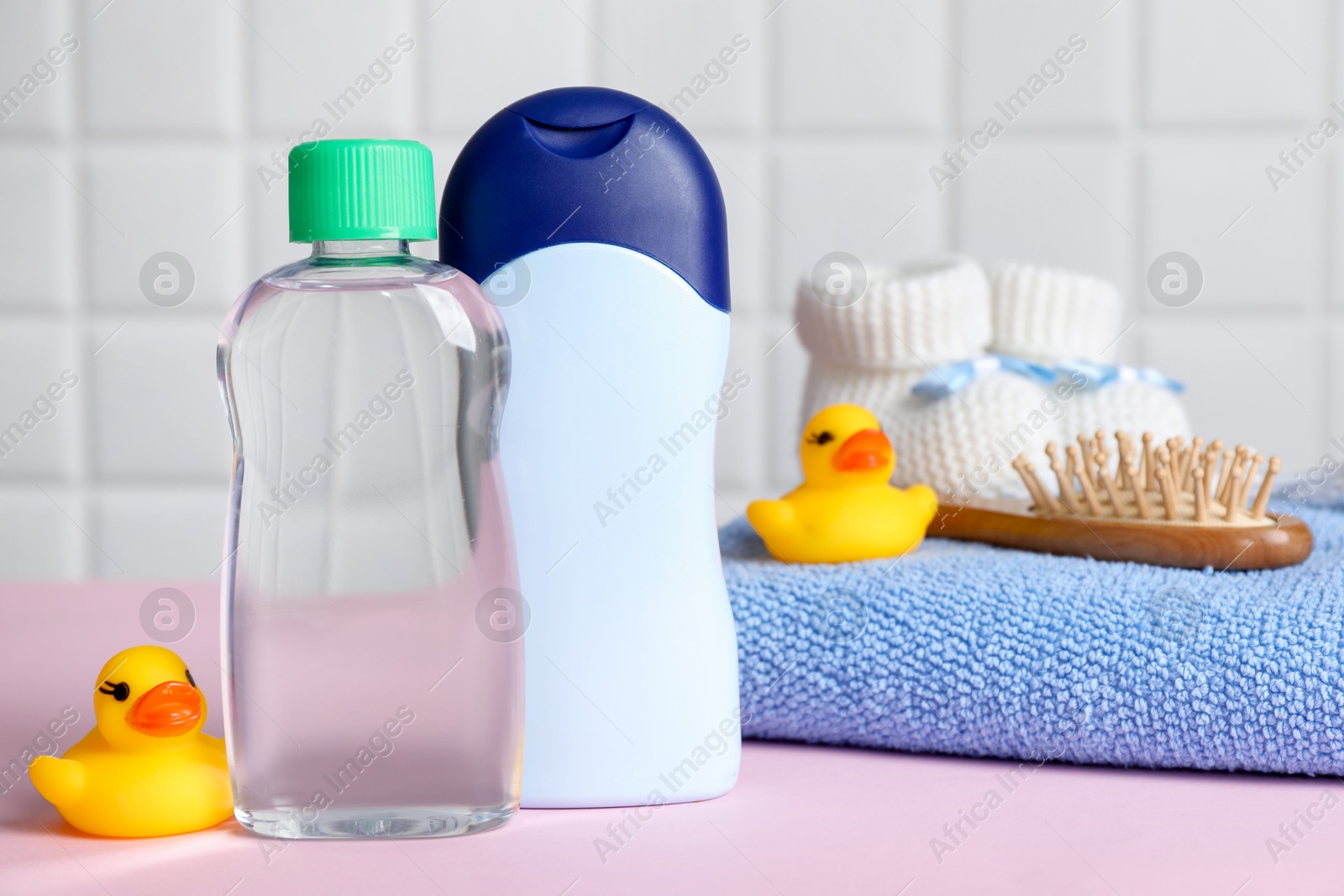 Photo of Baby oil and bath accessories on pink table