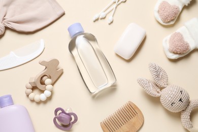 Photo of Baby oil and bath accessories on beige background, flat lay